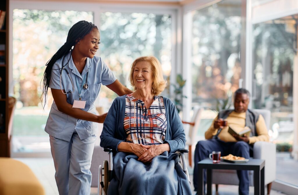 An assisted living staff member happily supporting a resident.
