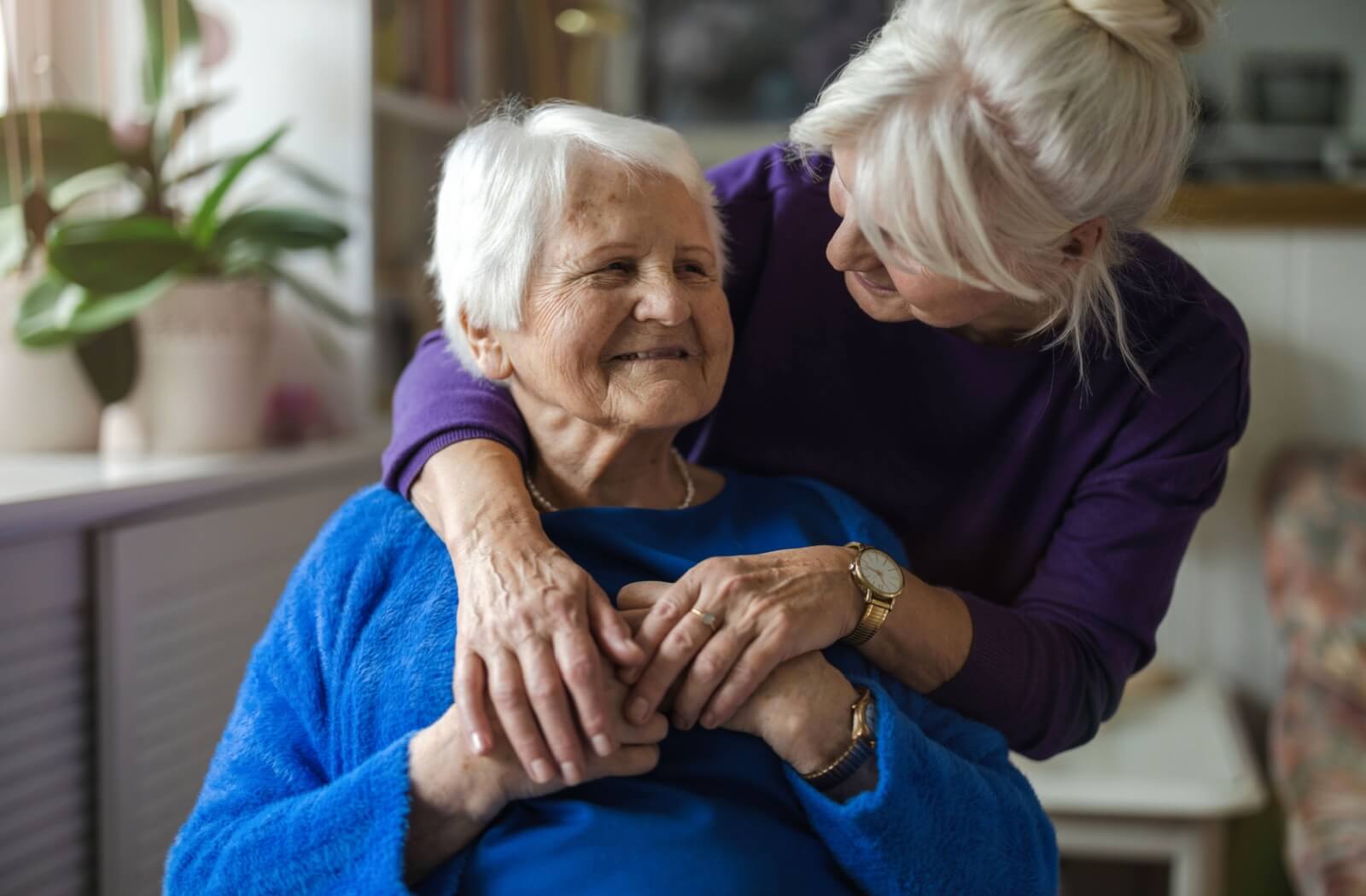 adult daughter hugging her senior mother in memory care