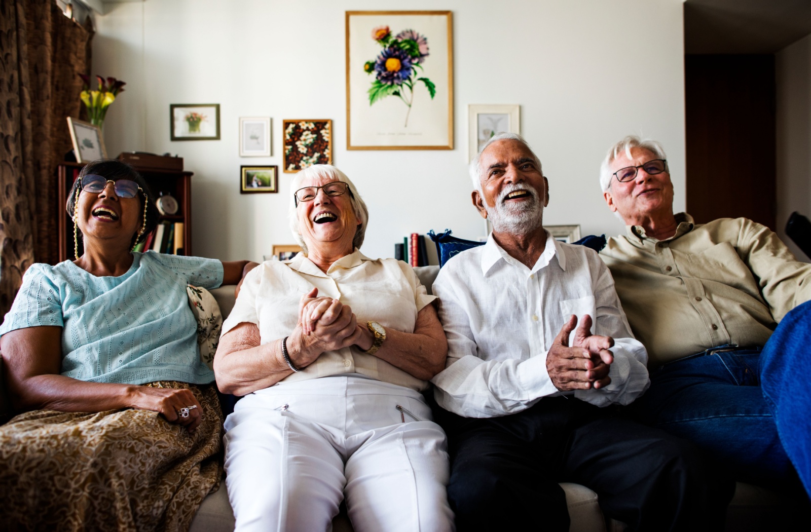 A group of seniors sitting on the couch and enjoying their time together in assisted living